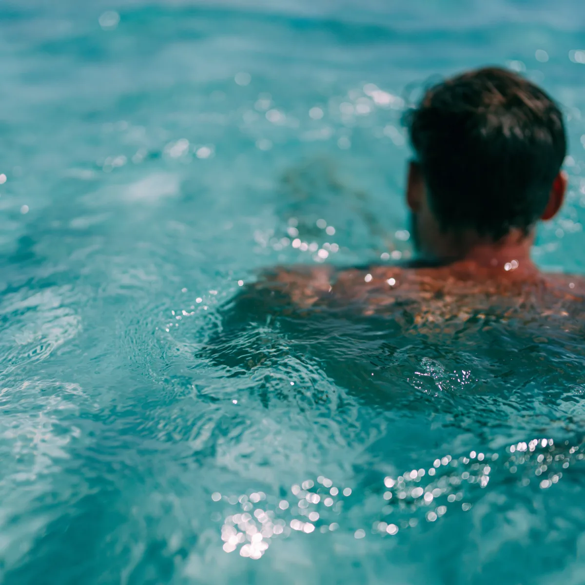 Türkisblaues Wasser — Person als weiche Silhouette beim Schwimmen
